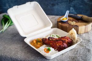 Curry, rice, chicken and naan bread in clamshell packaging